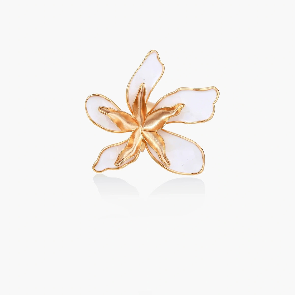 Gold-plated sculptural ring featuring white enamel petals forming an oversized lily bloom on adjustable band